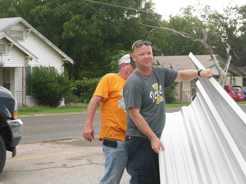 Image: Michael Chambers, Director of Operations for Italy ISD and Jackie Cate, Sr. with Cate Welding, help erect the covered walkway at Stafford Elementary.