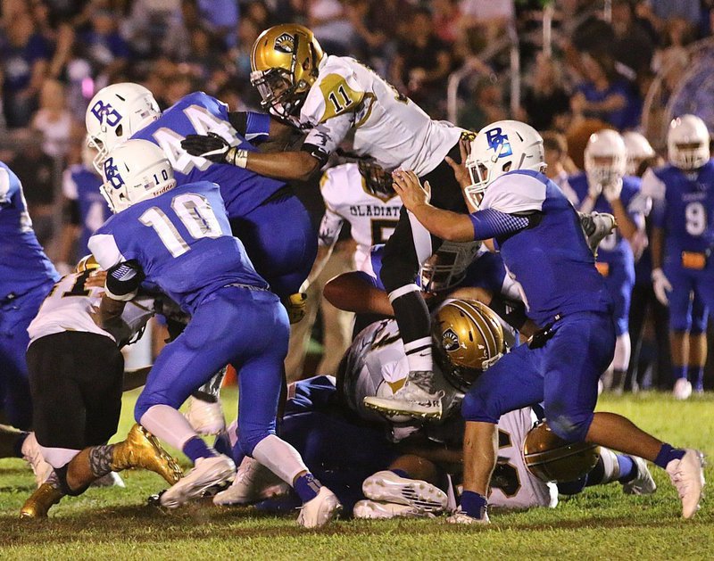 Image: The high-flying #11 Fabian Cortez(11) goes airborne to help strip the ball away from a Blooming Grove running back as teammate #81 Dylan McCasland hits the Lion low.
