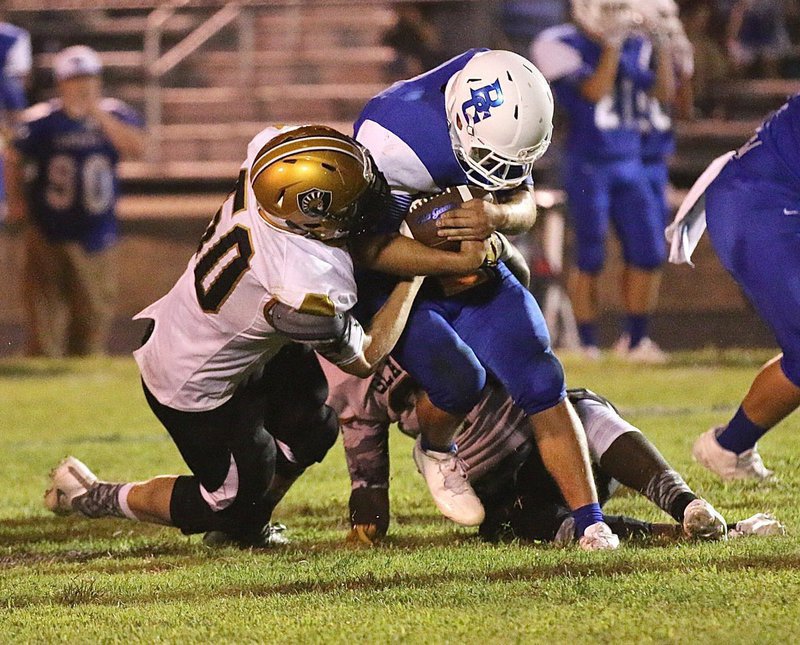 Image: Gladiator junior defensive end #50 Clay Riddle helps tackle a Blooming Grove ball carrier along with teammate #24 Christion Washington.