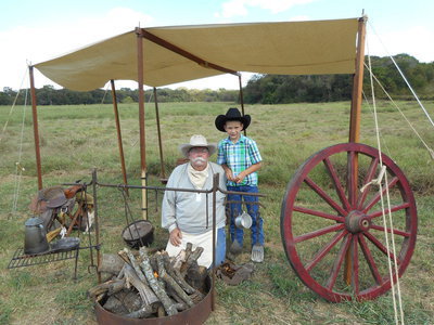 Image: David Vantreese with his grandson, Regan Fletcher, shown with 1870s typical campsite for a cattle drive.