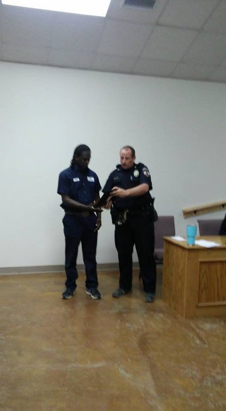 Image: Police Chief Cameron Beckham presents Greg Anderson a plaque honoring him for bravery.