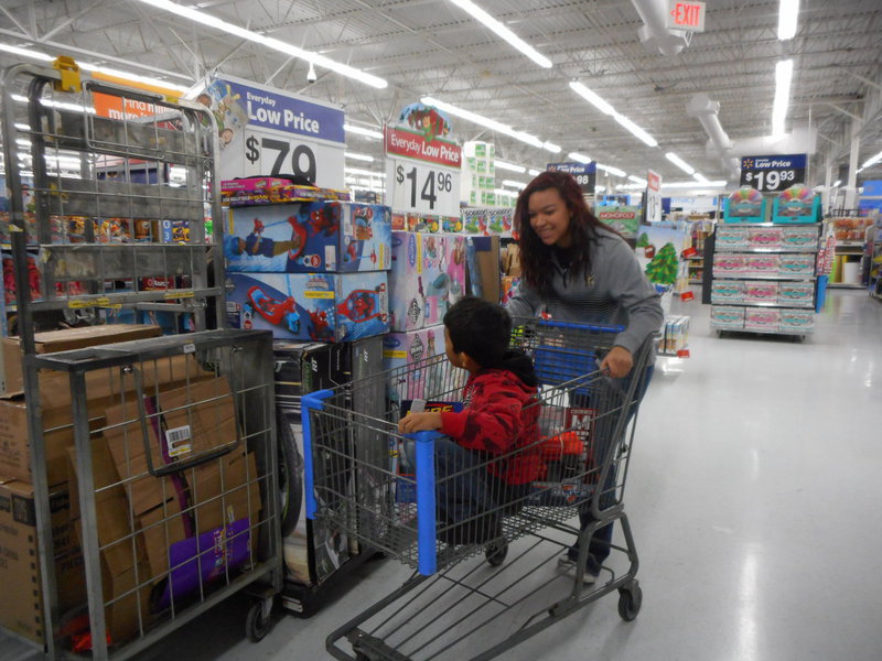 Image: April Lusk helps one of the students with his shopping.