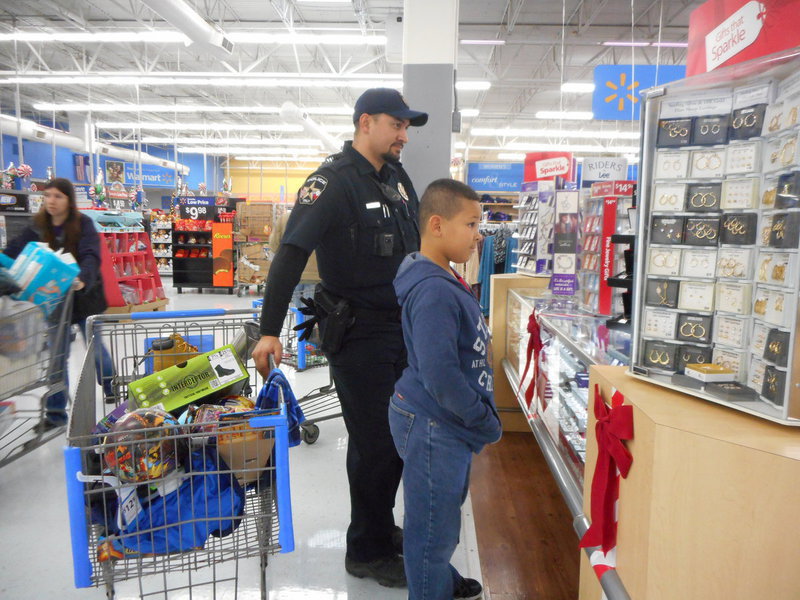 Image: Officer Baron gladly helps a student shop for his family.